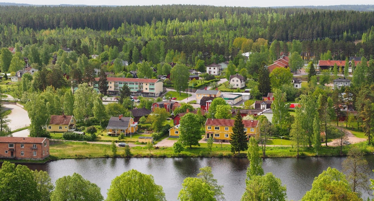 Utsikt över Silverdalen, hus, träd och en å